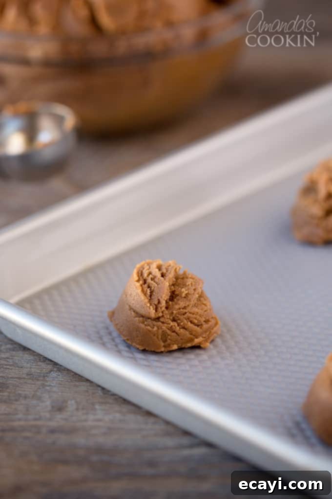 Decadent Nutella Peanut Butter Cookies 5 A step-by-step photo showing the mixing process of Nutella peanut butter cookie dough in a large bowl with an electric mixer.