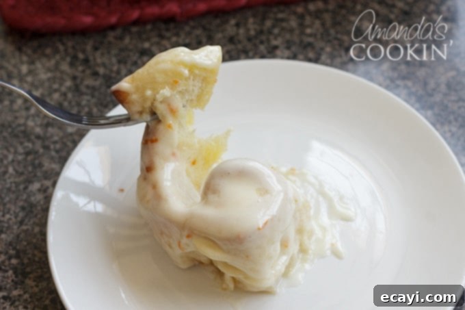 You'll love these orange rolls just as much as homemade cinnamon rolls. This quick orange rolls recipe is ideal for those who prefer homemade over canned. #orangerolls #cinnamonrolls #breakfastrolls #orange #creamcheese #creamcheesefrosting #sweetrolls #orangerollsrecipe #breakfast #sweetrollrecipe pulling apart orange rolls
