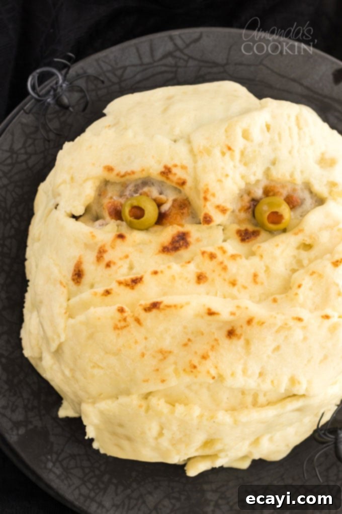 This Mummy Meatloaf is a super fun way to get kids to eat their dinner, perfect for Halloween! This mummy meatloaf is a great conversation starter! mummy meatloaf on a plate, ready to be served for Halloween dinner