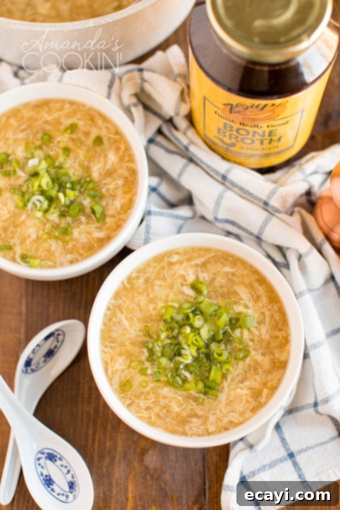 Easy Homemade Egg Drop Soup recipe, perfect for a quick appetizer or comforting light meal. Better than takeout! two bowls of steaming homemade egg drop soup garnished with green onions