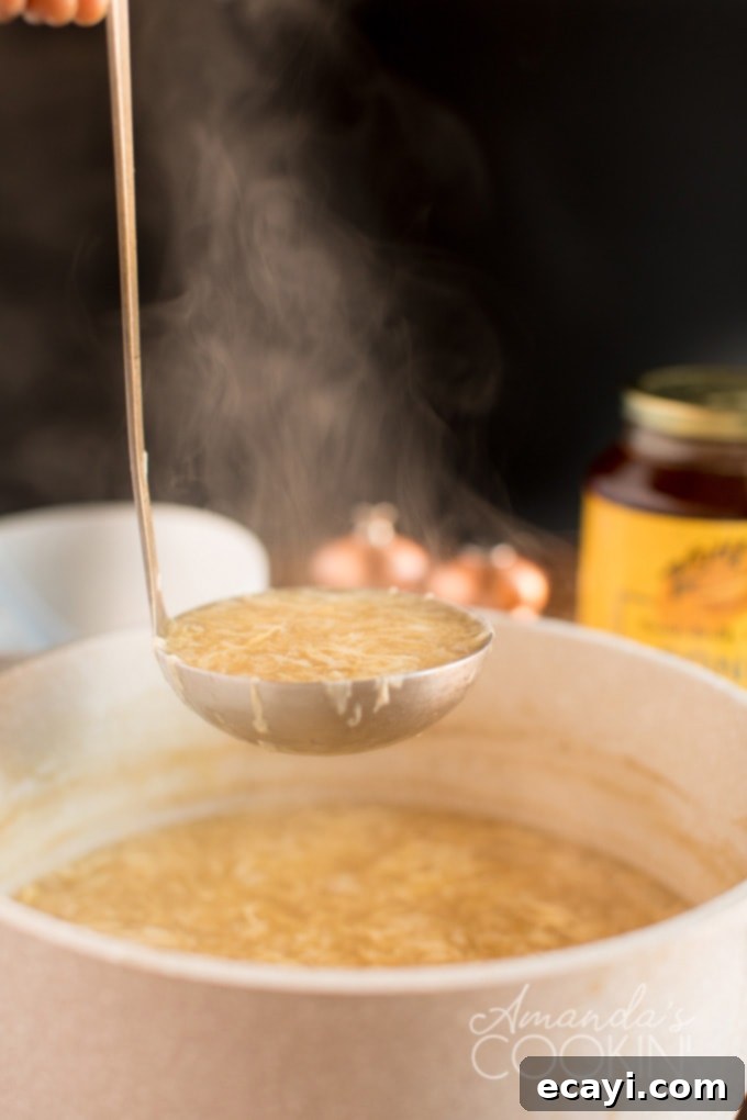 Serving authentic homemade Egg Drop Soup from a large saucepan into small bowls. ladle full of fresh homemade egg drop soup coming out of a saucepan, ready to be served