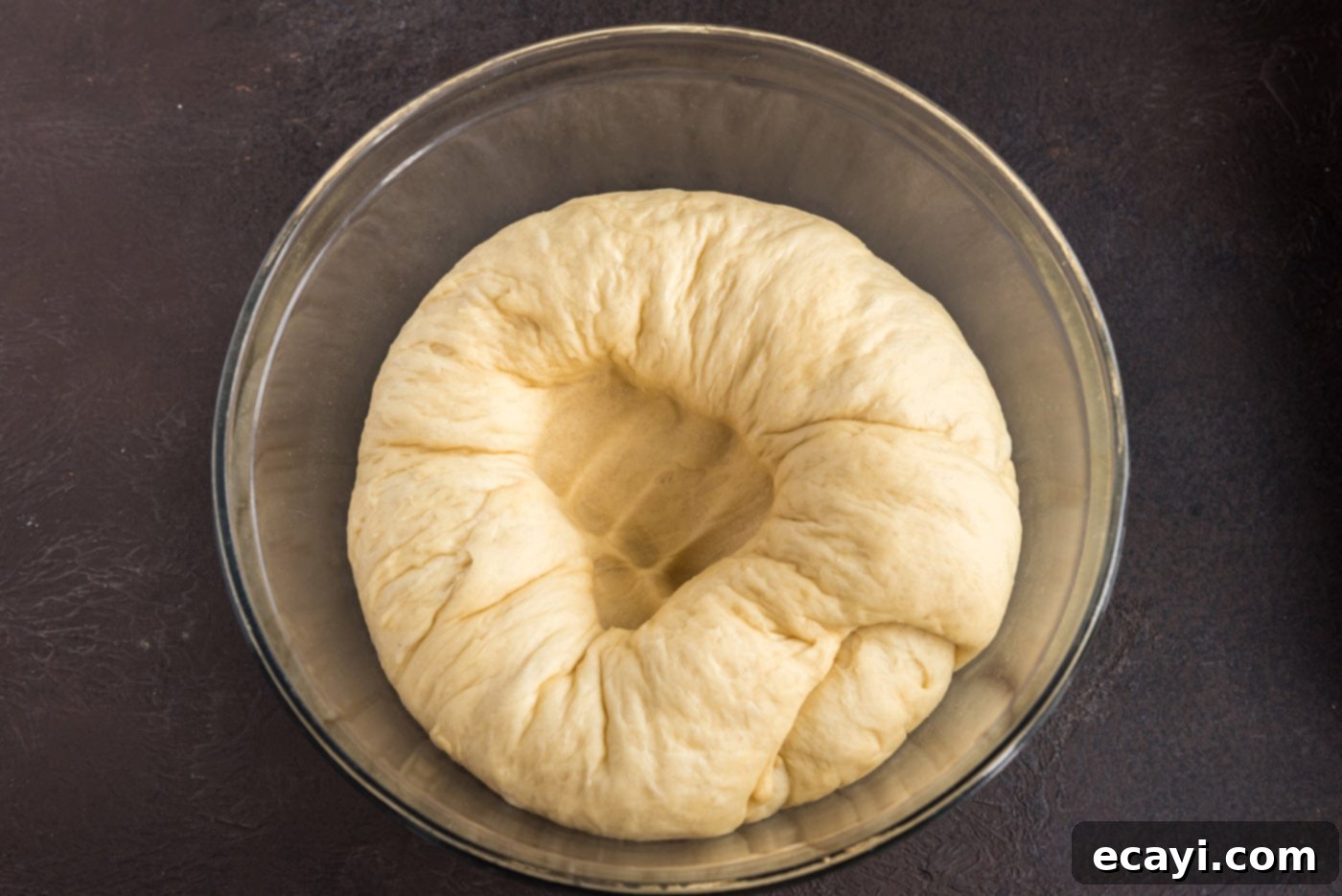Hearty German Party Loaf 16 punching a hole into yeast dough in a bowl
