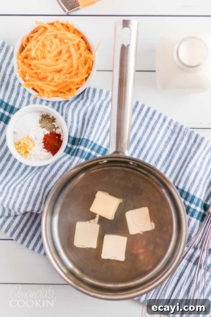 My stovetop mac and cheese recipe is easy to make, uses a homemade cheese sauce, and is perfectly creamy. Make this mac and cheese today! #macaroni #macandcheese #cheese #sides #dinnersides #lunch #pasta A flat lay of the essential ingredients for making stovetop mac and cheese: pasta, butter, flour, spices, milk, and cheese.