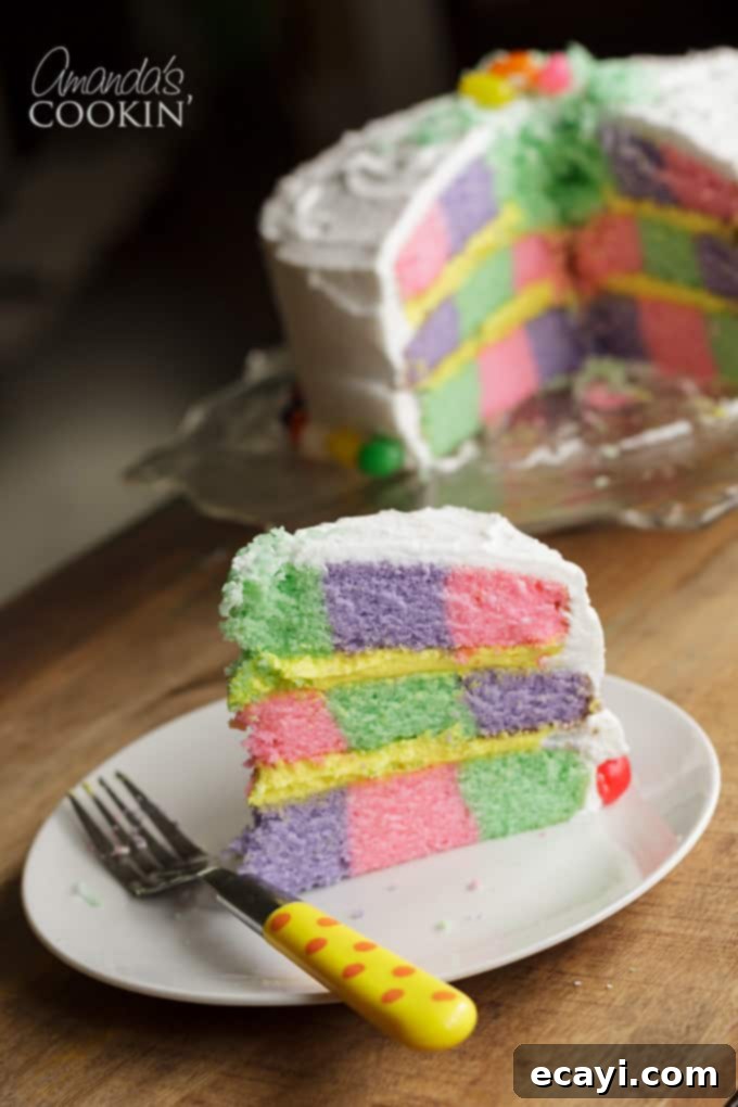 This Checkerboard Cake is the perfect treat for Easter- impress your friends and family with a colorful cake for the holiday! #easter #easterdessert #easterrecipes #cake #checkerboardcake #cakerecipes #cutefood #frosting checkerboard cake slice