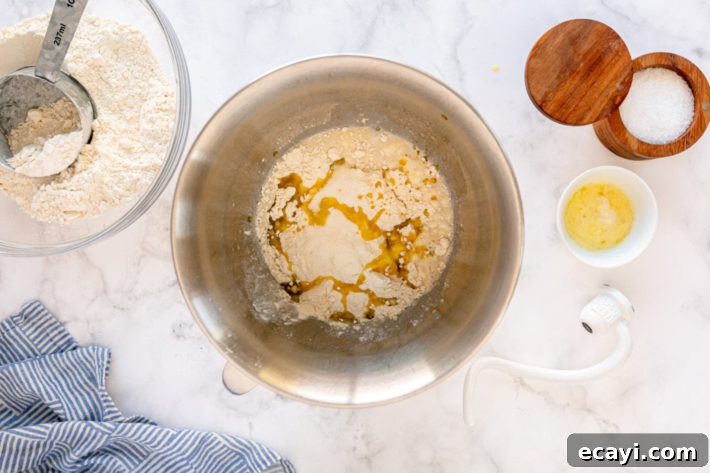 Irresistible Tear-and-Share Dinner Buns 5 Activating yeast in a mixing bowl with warm milk and sugar, forming a bubbly mixture.