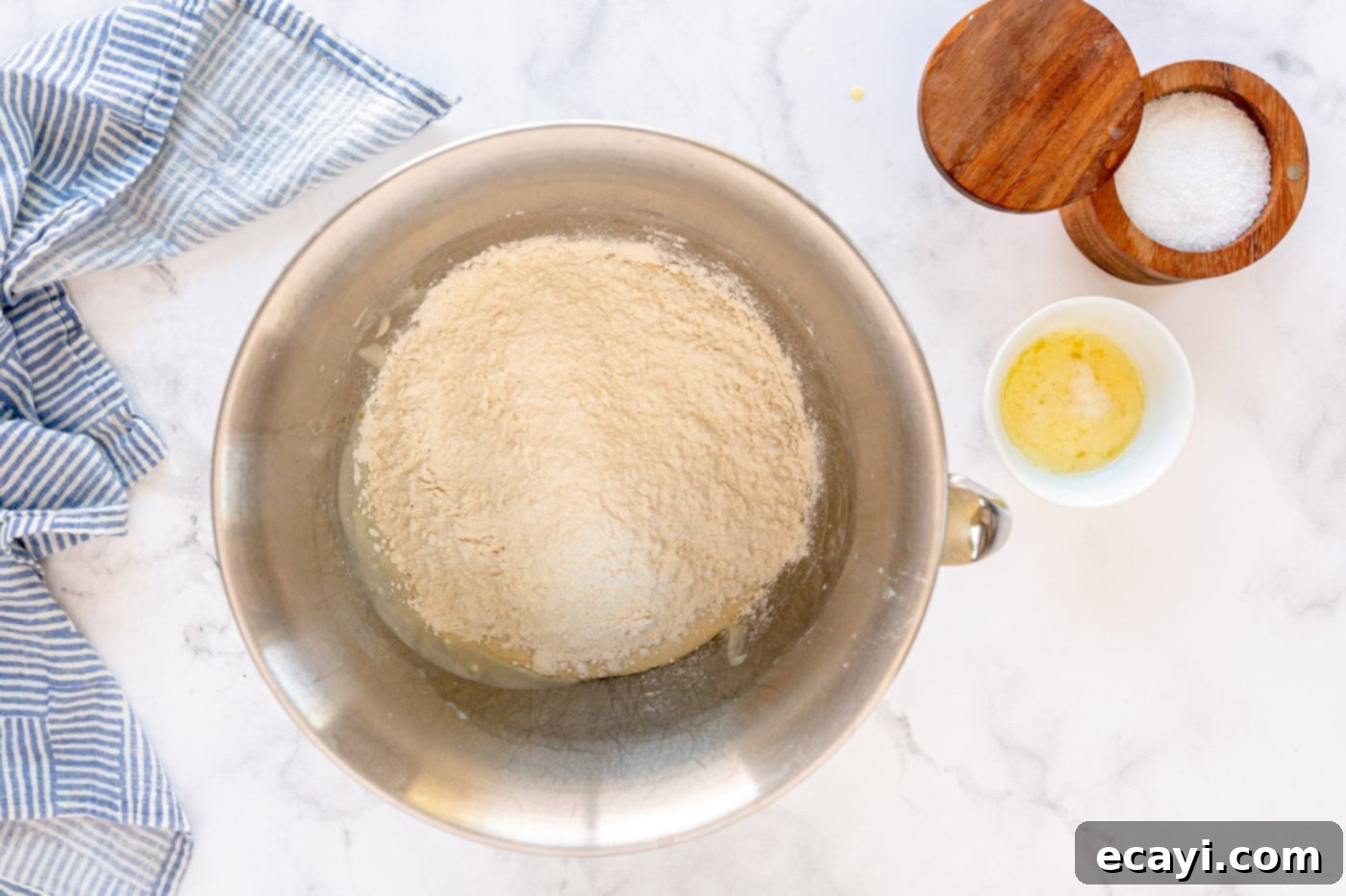 Irresistible Tear-and-Share Dinner Buns 6 Adding remaining flour to the yeast mixture in a stand mixer, creating a soft dough.