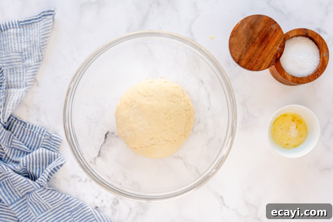 Irresistible Tear-and-Share Dinner Buns 7 Dough resting in a bowl, covered for its first rise in a warm place.
