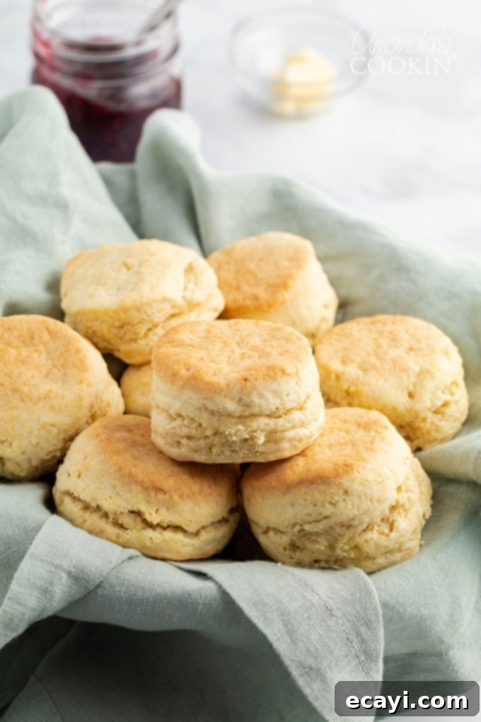 This recipe for flaky homemade biscuits only has 5 ingredients and comes together quickly, getting them on the table in about half an hour. A charming woven basket overflowing with freshly baked, golden-brown homemade biscuits, radiating warmth and home comfort.