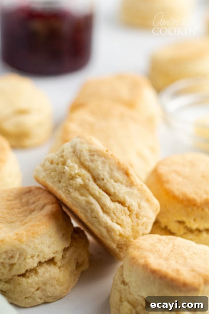 This recipe for flaky homemade biscuits only has 5 ingredients and comes together quickly, getting them on the table in about half an hour. A close-up shot of several homemade biscuits neatly stacked, highlighting their golden crusts and inviting texture.