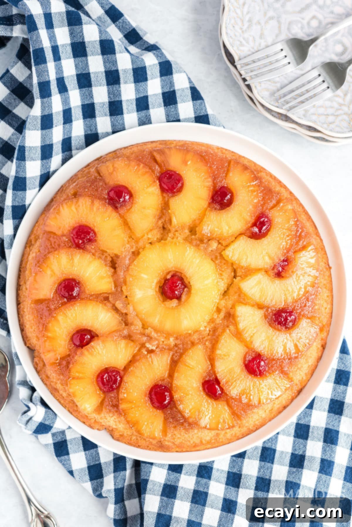 There's nothing quite like a pineapple upside down cake that's been baked to caramely perfection in a seasoned cast iron skillet! overhead photo of a freshly baked pineapple upside down cake in a cast iron skillet, showcasing its golden caramel crust and vibrant pineapple slices