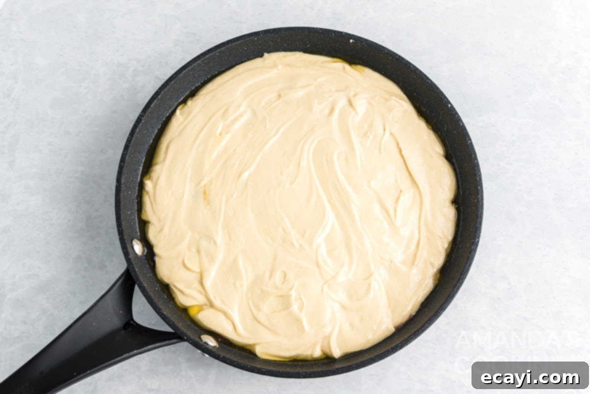 Golden Skillet Pineapple Flip 10 cake batter spread evenly in a cast iron skillet, ready for baking