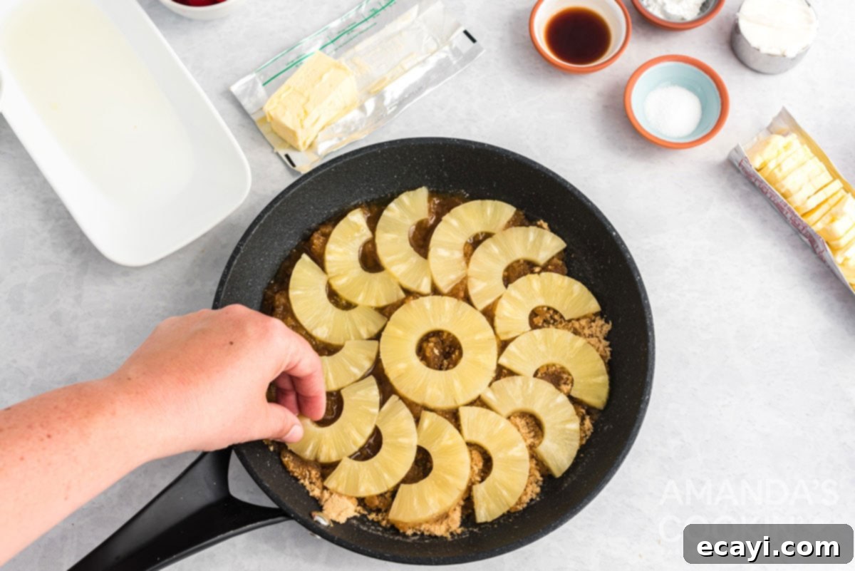 Golden Skillet Pineapple Flip 4 arranging pineapple slices in a cast iron skillet over brown sugar and butter