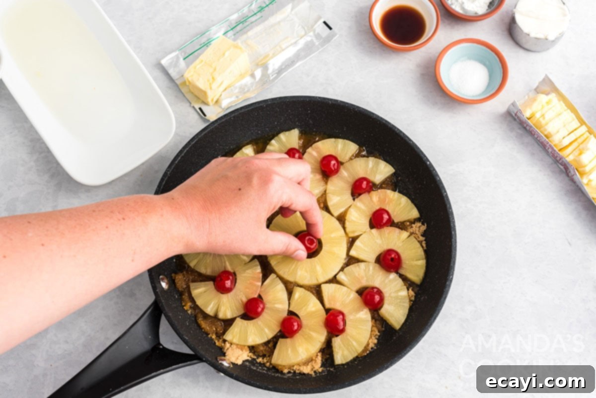 Golden Skillet Pineapple Flip 5 placing maraschino cherries in the center of pineapple rings in a skillet
