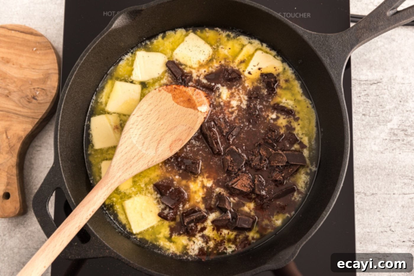 Cast Iron Chocolate Dream 5 chopped chocolate and butter in a cast iron skillet with wooden spoon
