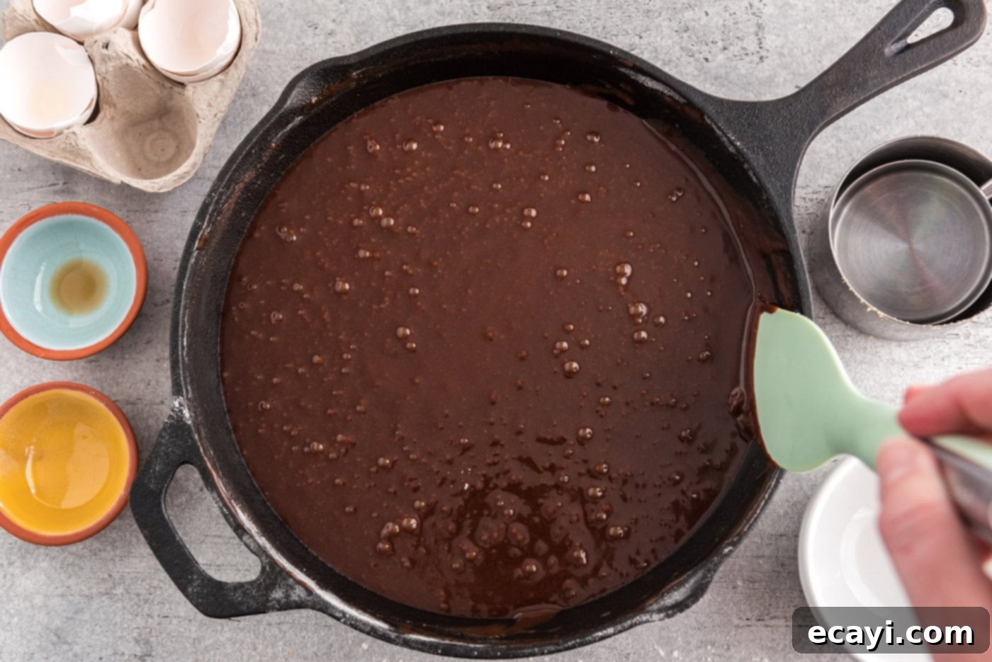 Cast Iron Chocolate Dream 9 cleaning edges of brownie skillet with a rubber spatula