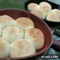 Fluffy Homemade Dinner Rolls Made Simple 2 A close up photo of homemade dinner rolls in two cast iron skillets.