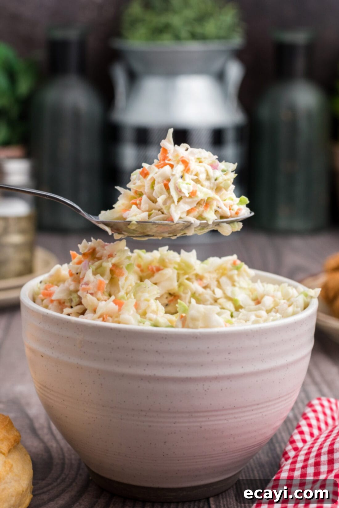 This copycat KFC coleslaw recipe is delicious! You won't be able to tell the difference. This coleslaw recipe is the perfect gathering or potluck dish! #kfccoleslawrecipe #kfccoleslaw #kfccoleslawrecipecopycat #coleslawrecipe #restaurantrecipes #copycatrecipes #potluckrecipes #summerrecipes #bbqrecipes #barbecuerecipes #amandascookin A spoonful of homemade KFC coleslaw showcasing its creamy texture and finely chopped vegetables.