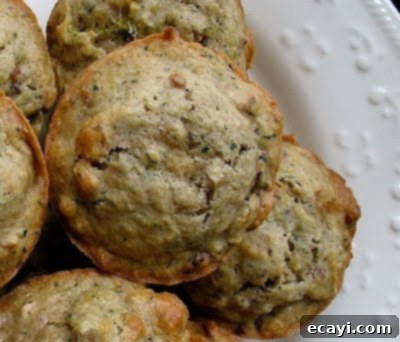 Vanilla-Kissed Zucchini Muffins 4 A close up overhead photo of a vanilla zucchini muffin with others in the background.