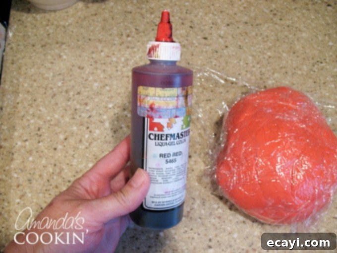 Spiderman Cake Magic: Homemade Marshmallow Fondant 5 Close-up of a tube of red gel food coloring, essential for Spiderman cake.
