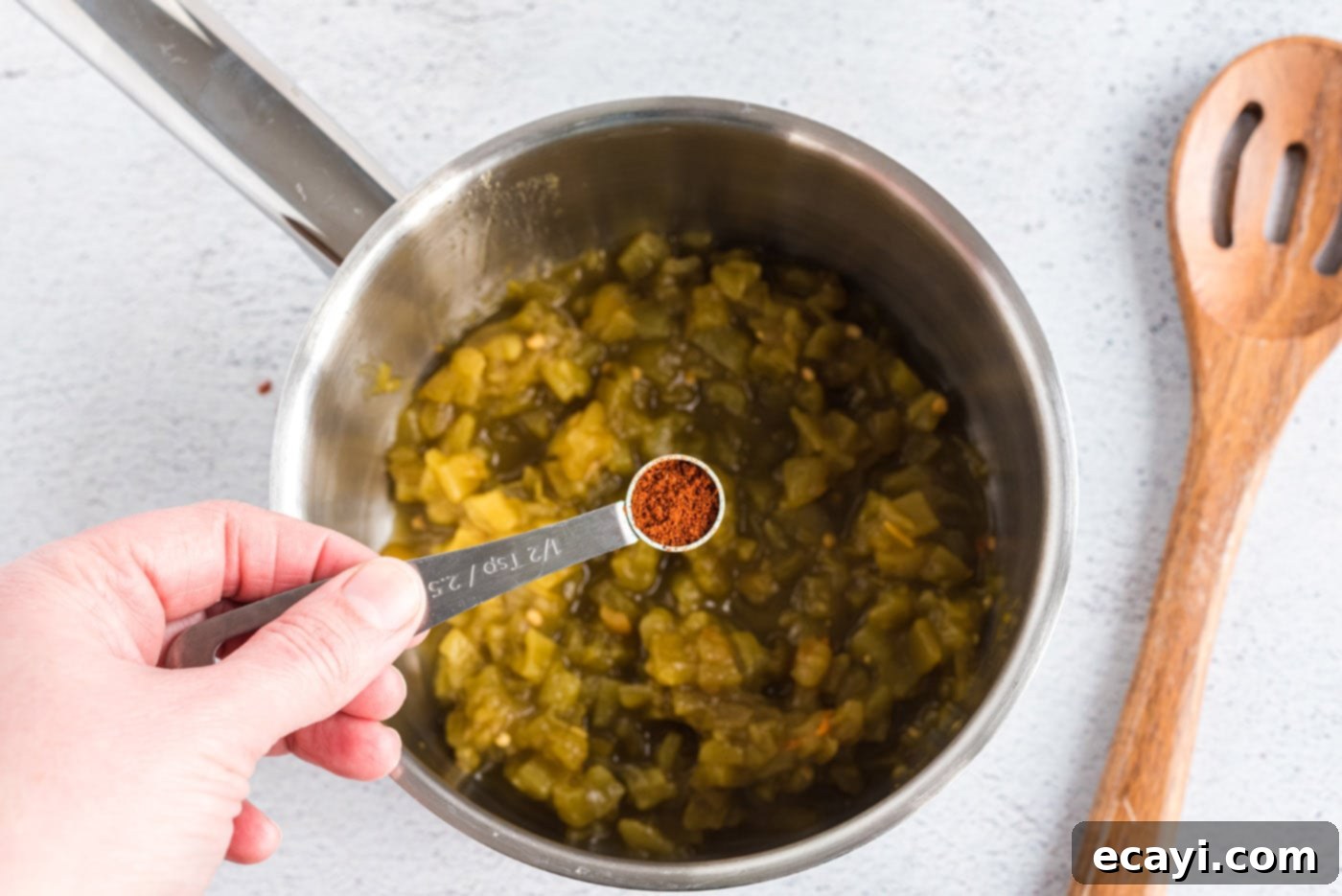 Classic Smothered Beef Enchiladas 11 Adding chile powder to green chiles in a saucepan