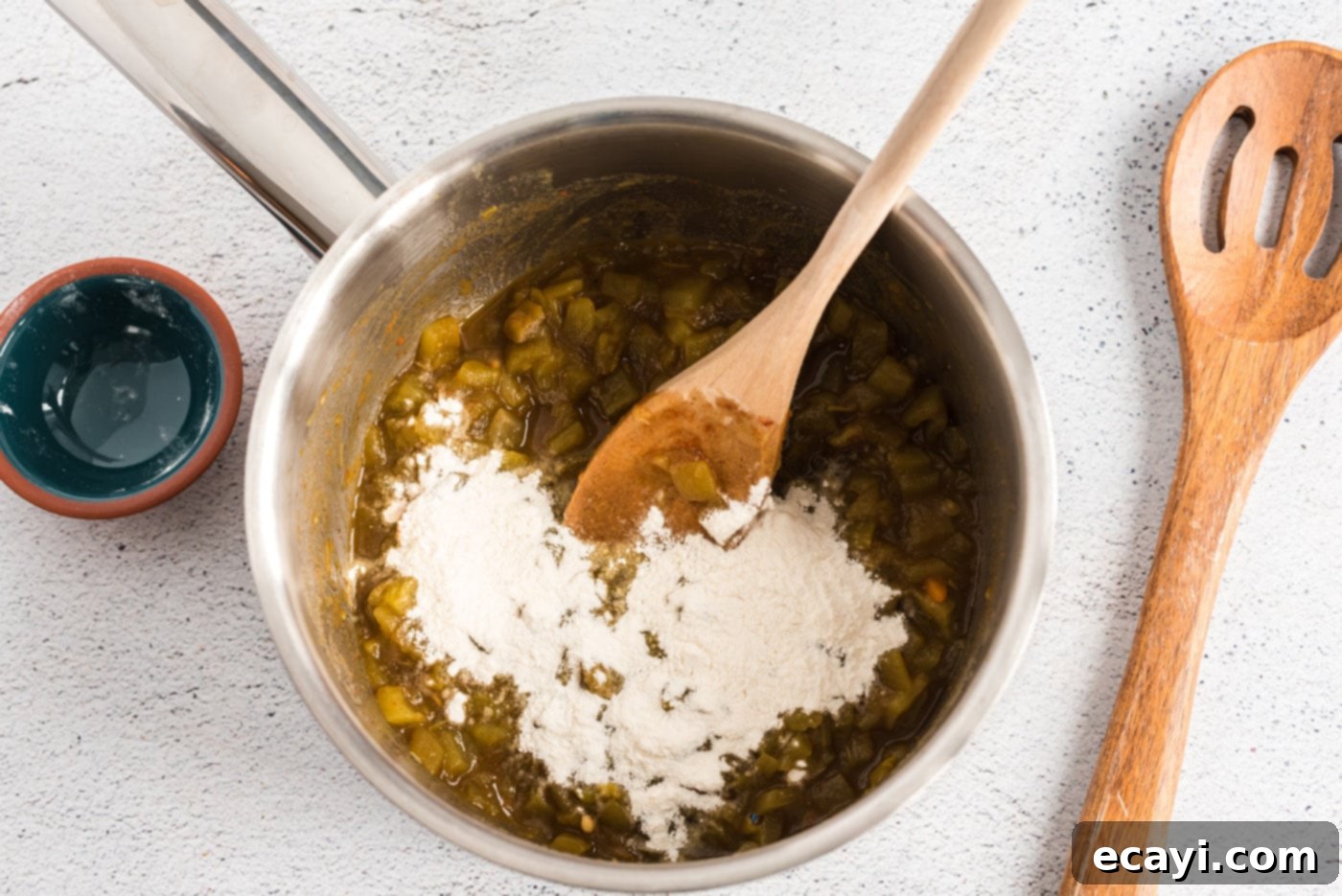 Classic Smothered Beef Enchiladas 12 Adding flour to green chiles in a saucepan to create a roux