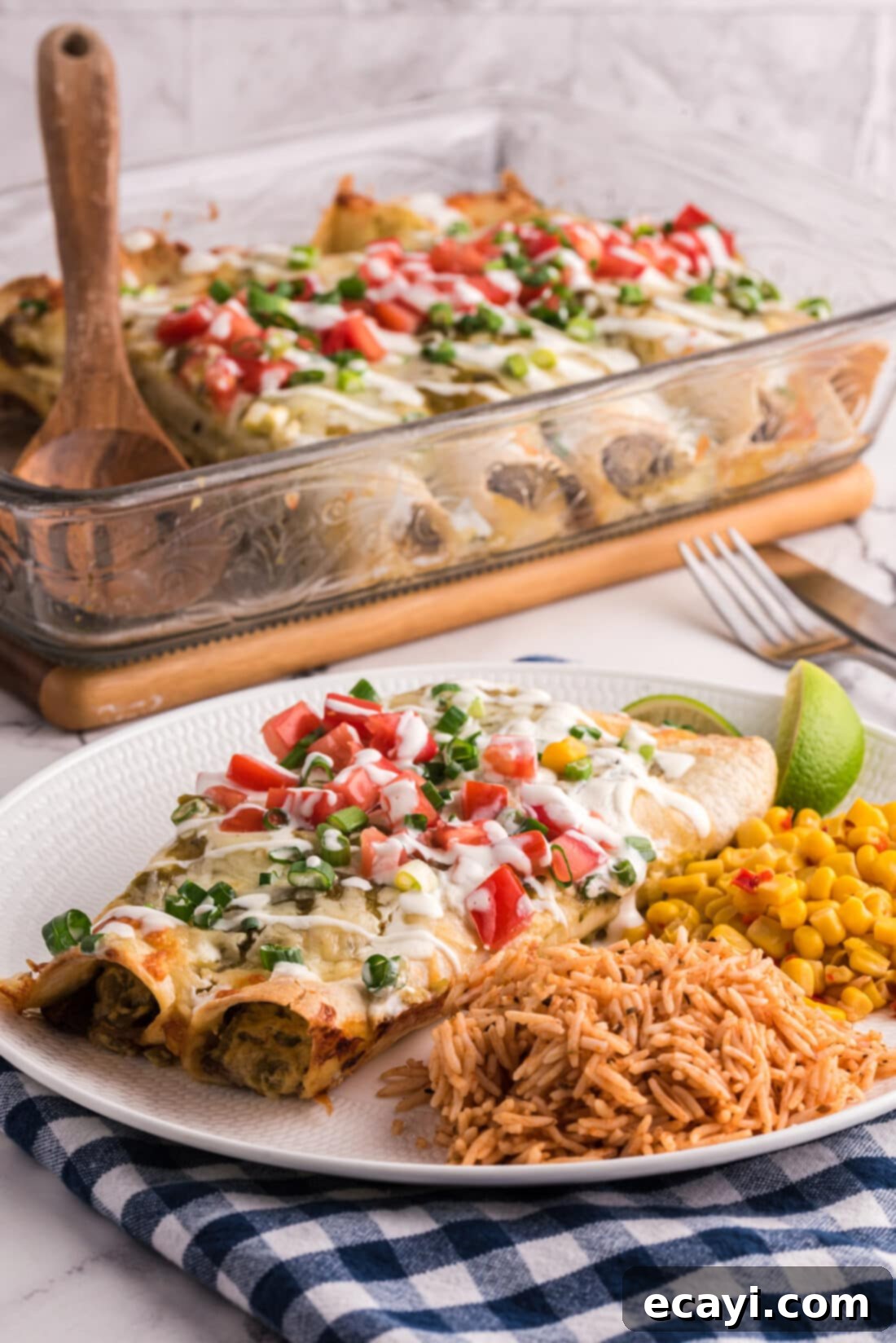 Classic Smothered Beef Enchiladas 19 Shredded Beef Enchiladas with rice on a plate, with the pan in the background