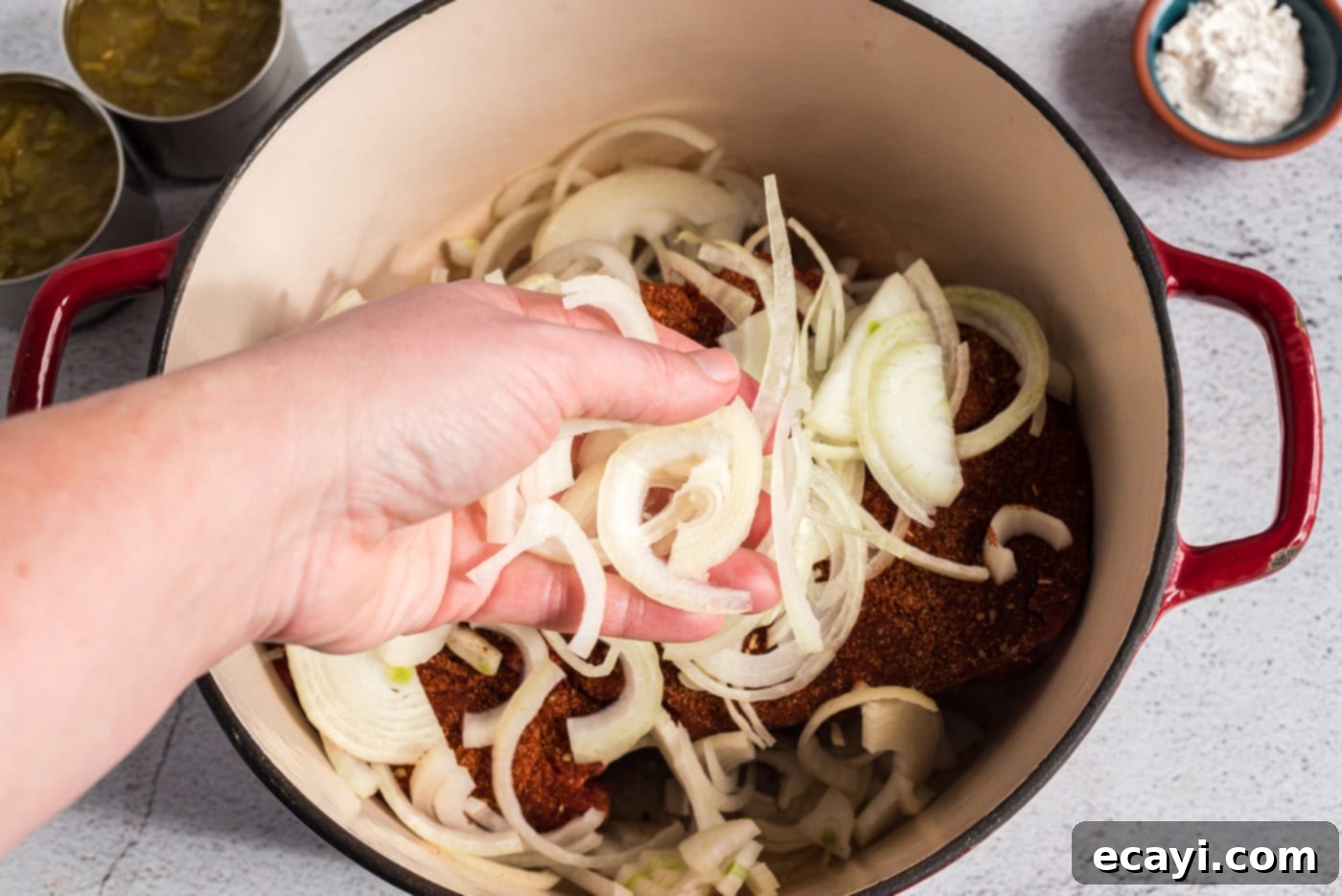 Classic Smothered Beef Enchiladas 6 Adding sliced onions to chuck roast in a roasting pan