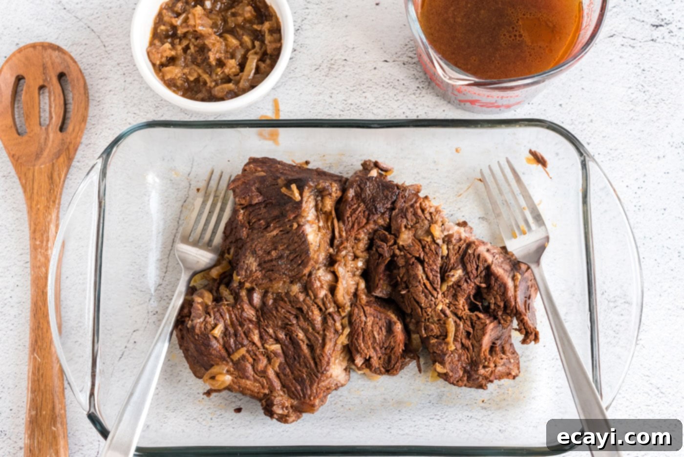 Classic Smothered Beef Enchiladas 8 Shredding tender beef with two forks for enchiladas