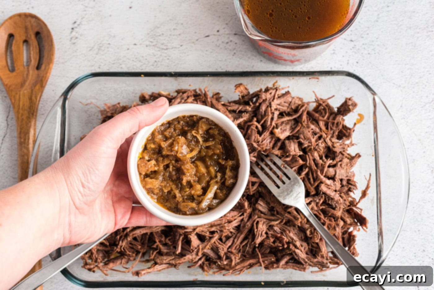 Classic Smothered Beef Enchiladas 9 Adding cooked onions to shredded beef