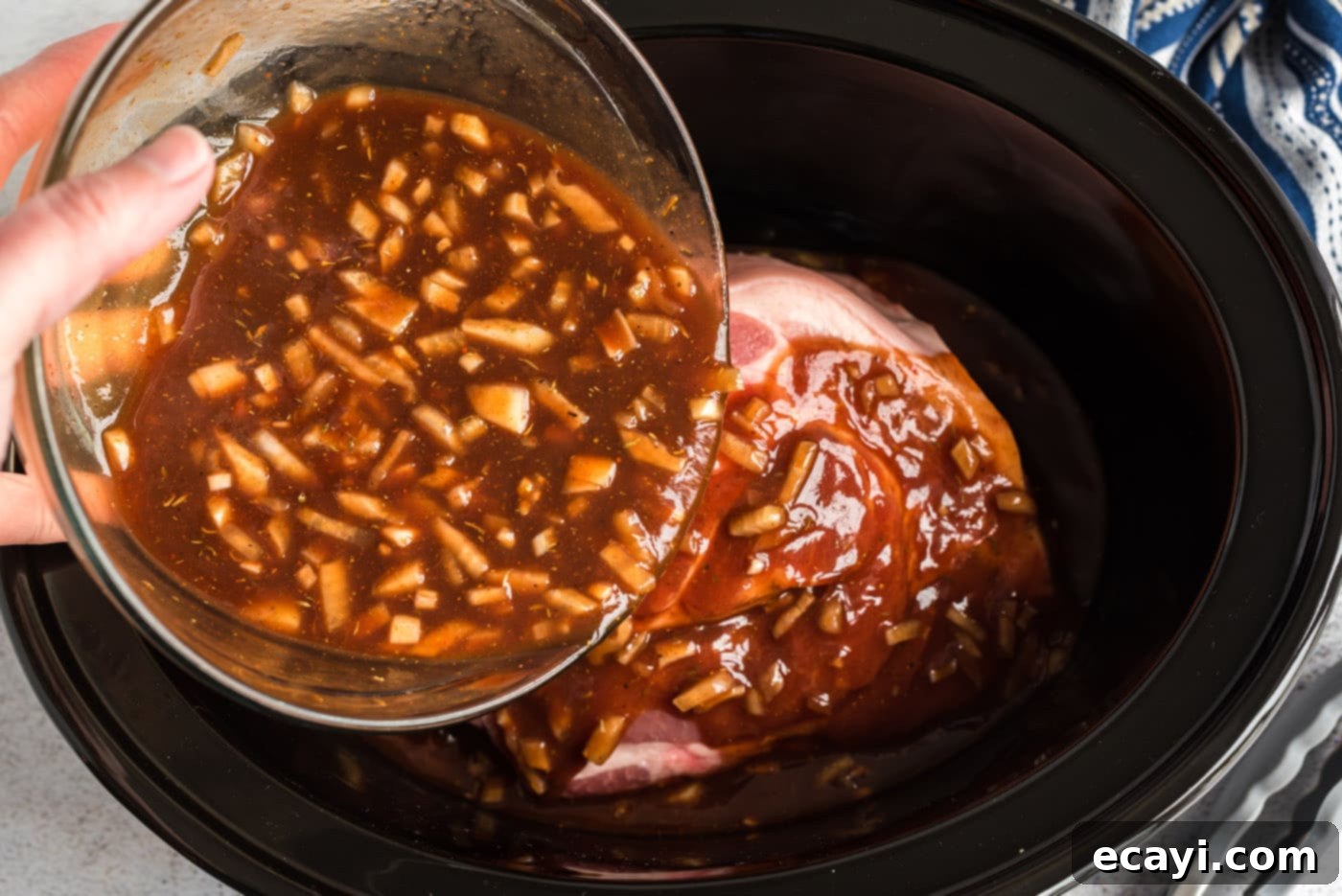 Fall-Apart Tender Slow Cooker Pulled Pork 7 pouring sauce over pulled pork in slow cooker