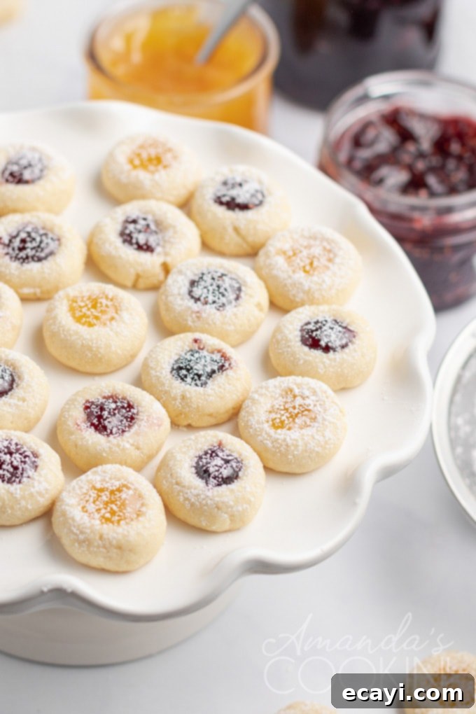 Soft and firm thumbprint cookies with sweet jam centers, a holiday favorite A vibrant plate filled with freshly baked jam thumbprint cookies, perfect for holiday gatherings