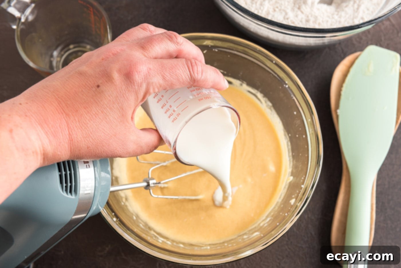 Apple Cider Doughnuts 11 pouring buttermilk into apple cider donut batter