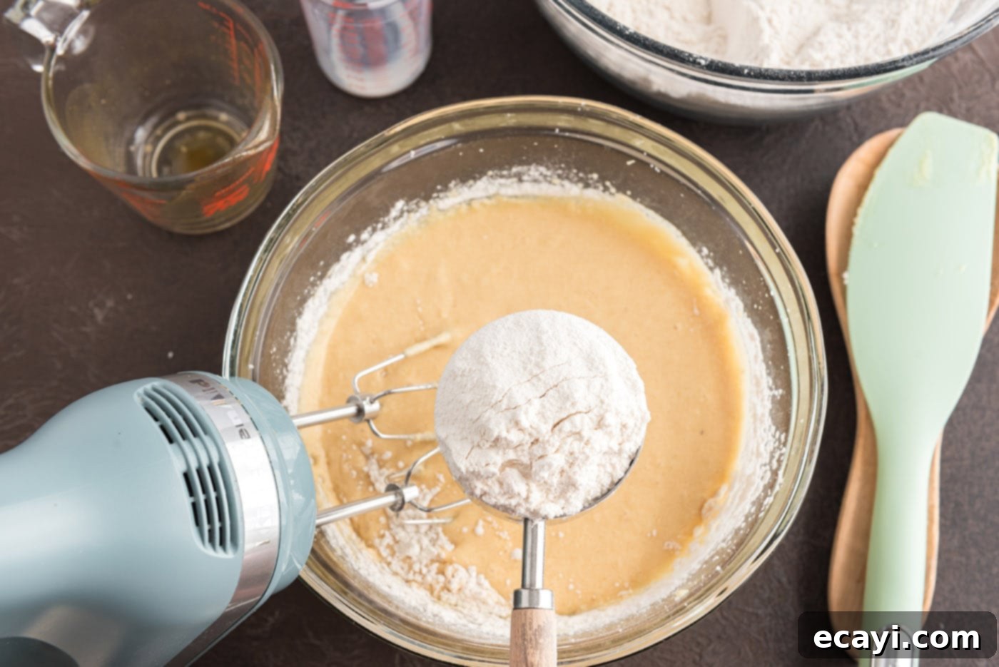 Apple Cider Doughnuts 13 adding flour mixture to wet ingredients in a bowl for doughnut dough