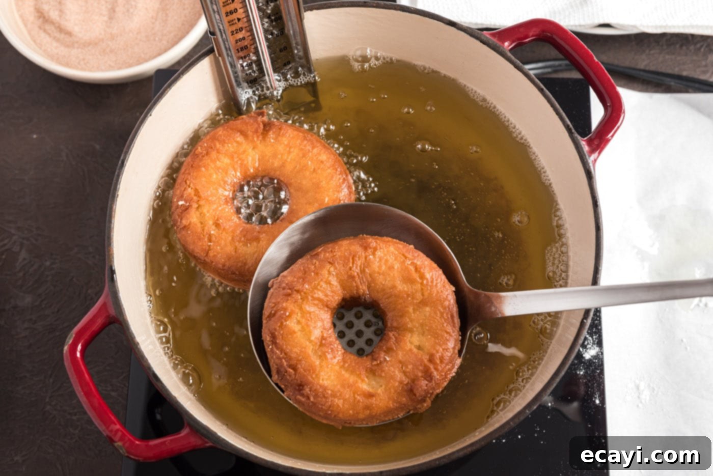 Apple Cider Doughnuts 24 fried donuts being lifted from hot oil, showcasing their golden brown color