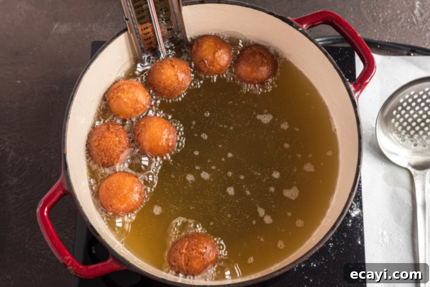 Apple Cider Doughnuts 25 fried donut holes being lifted out of oil, perfectly golden and crisp