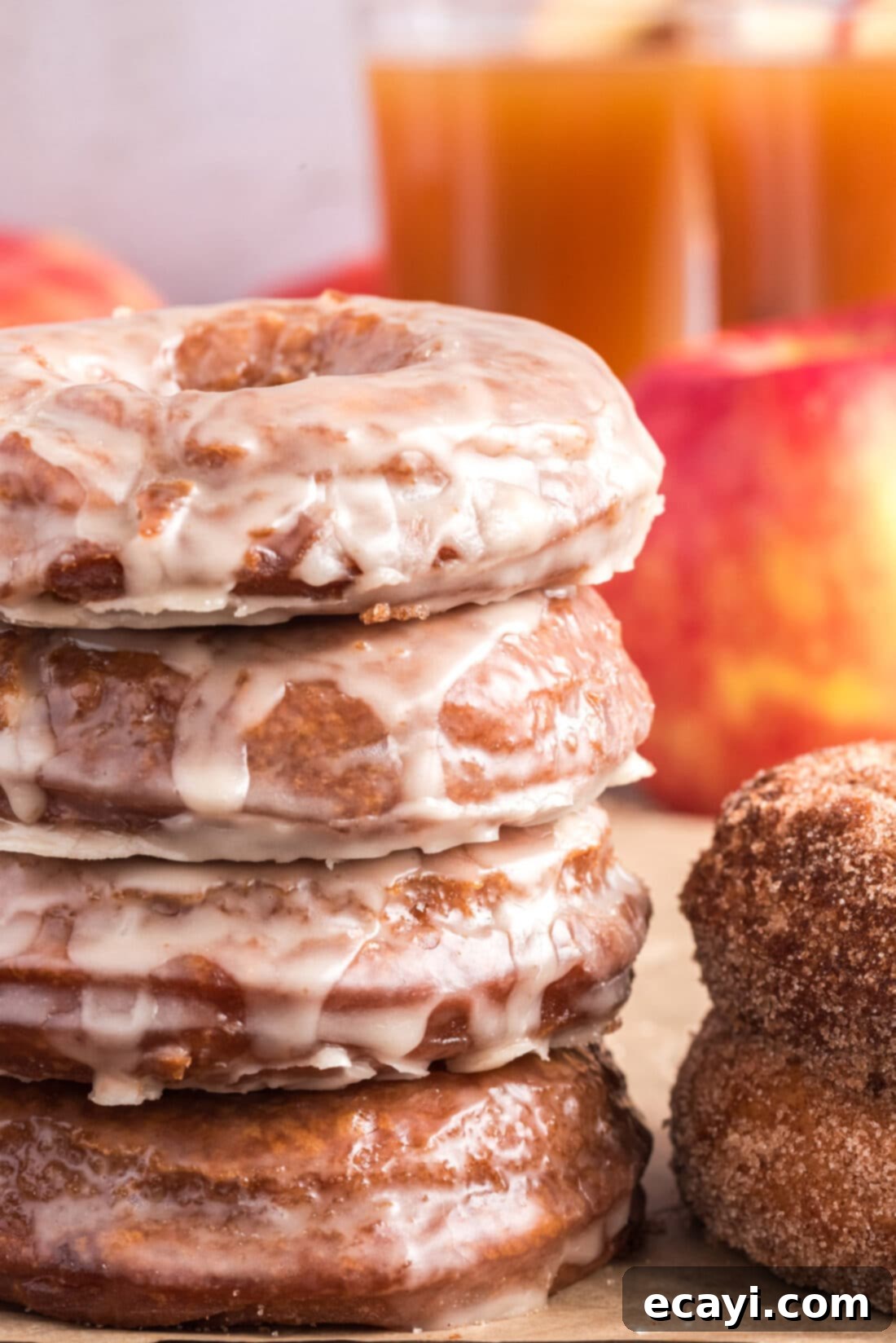 Apple Cider Doughnuts 28 Stack of glazed Apple Cider Doughnuts, glistening with sweet icing, ready to be enjoyed.