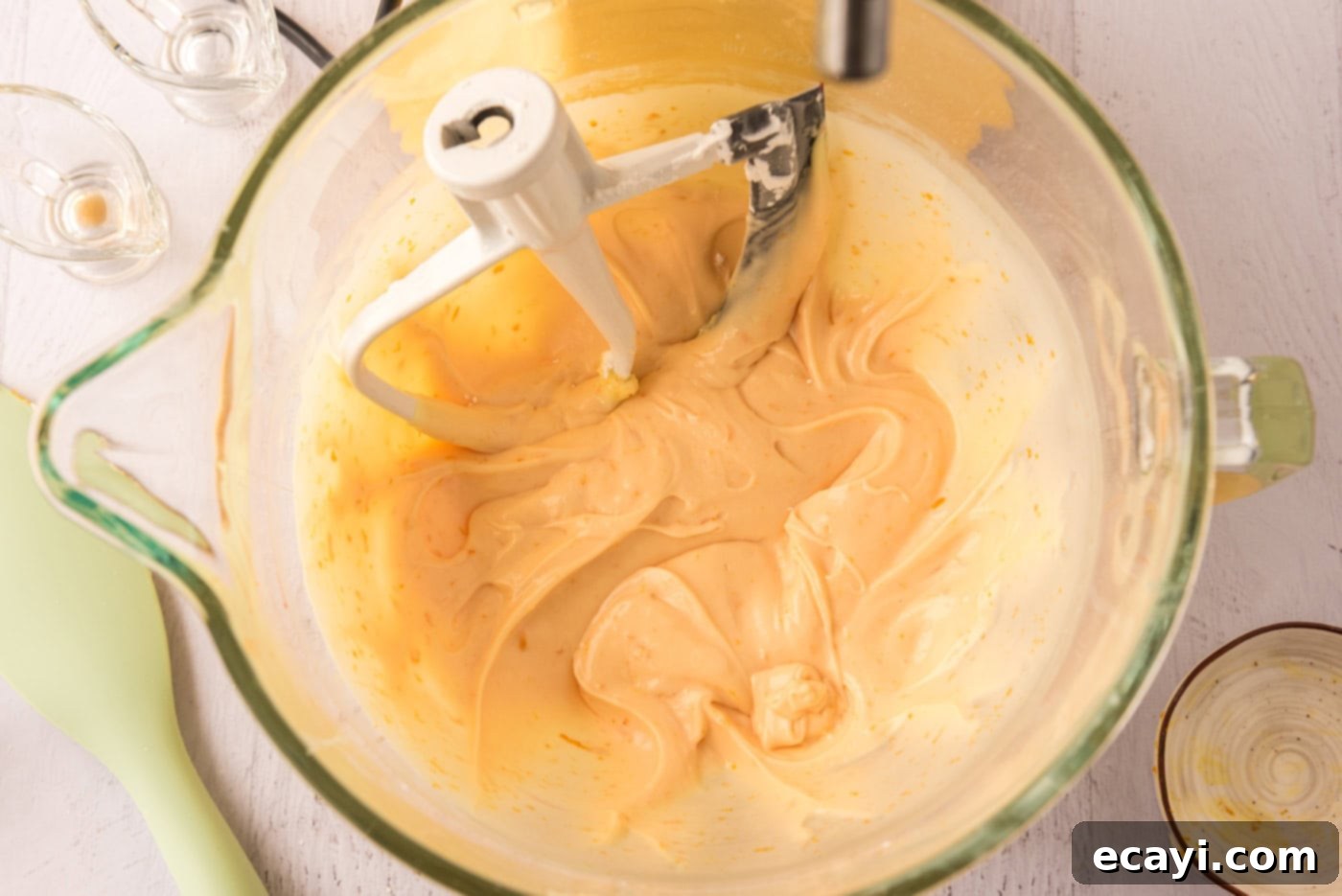 Orange Dream Swirl Cupcakes 12 Vibrant orange creamsicle frosting mixed in a stand mixer bowl.