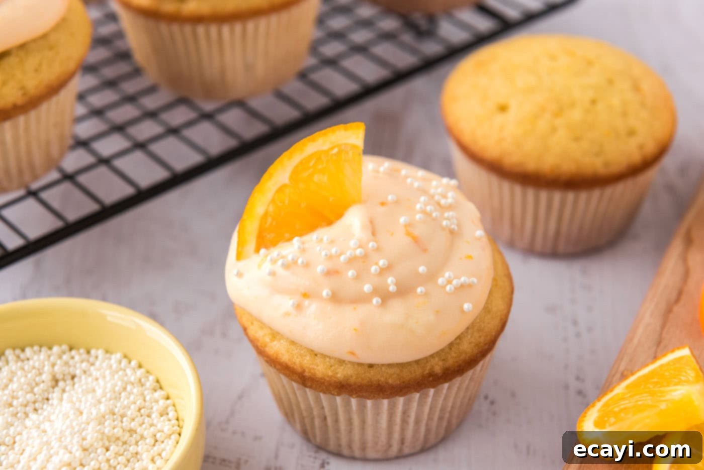 Orange Dream Swirl Cupcakes 14 Finished creamsicle cupcakes garnished with an orange wedge and sprinkles.