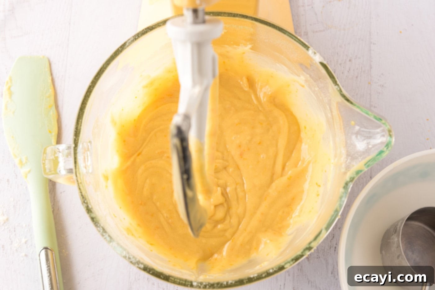 Orange Dream Swirl Cupcakes 8 Orange cupcake batter swirling in a stand mixer bowl.