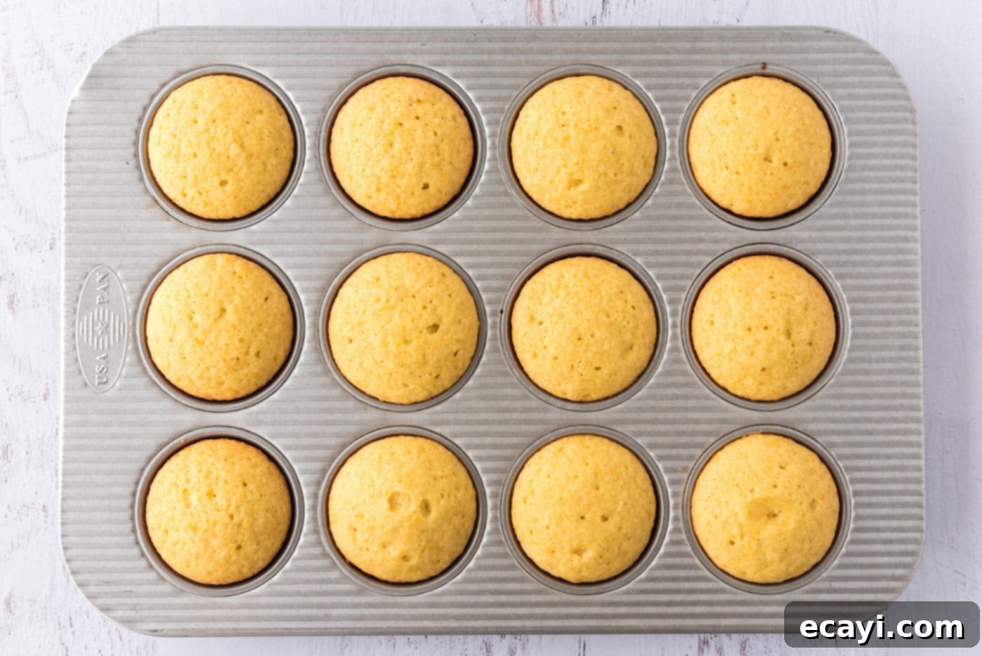Orange Dream Swirl Cupcakes 10 Freshly baked orange creamsicle cupcakes cooling in a pan.