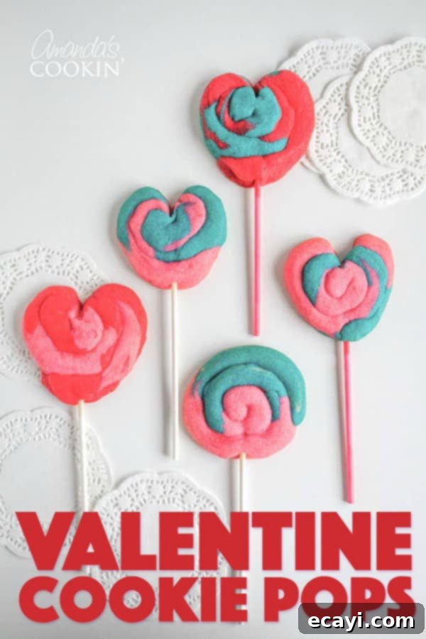 These Valentine Play Dough Cookie Pops are a fun colorful treat for the kids to help make and give to their friends or teacher. #cookies #valentinesday #valentinesdaytreats #valentine #baking #dessert #kids Valentine's Day Cookie Pops arranged on a decorative plate, ready for serving