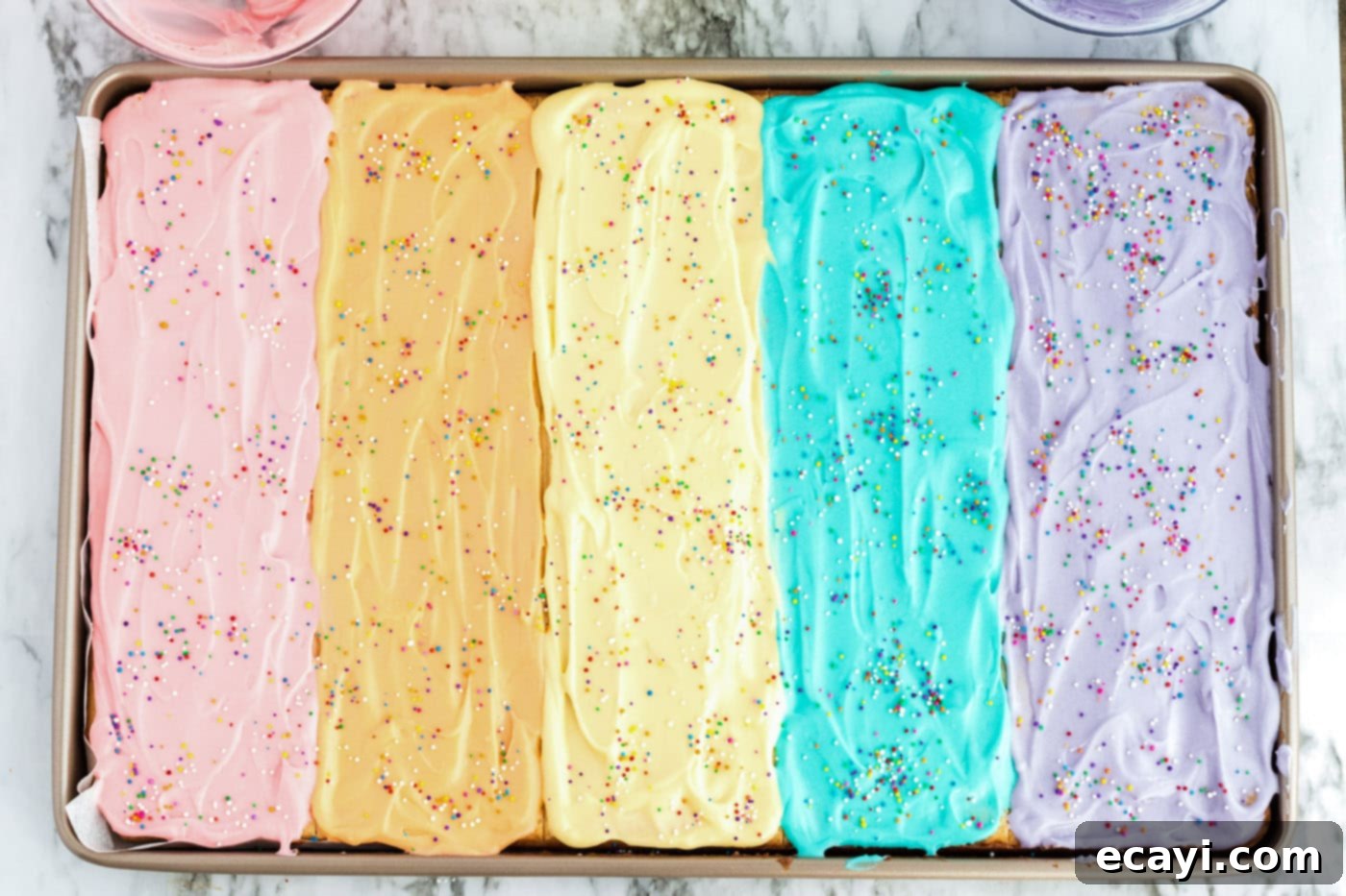 Irresistible Frosted Sugar Cookie Bars 12 Close-up of frosted sugar cookie bars in a jelly roll pan, richly topped with an assortment of colorful sprinkles, enhancing their festive look.