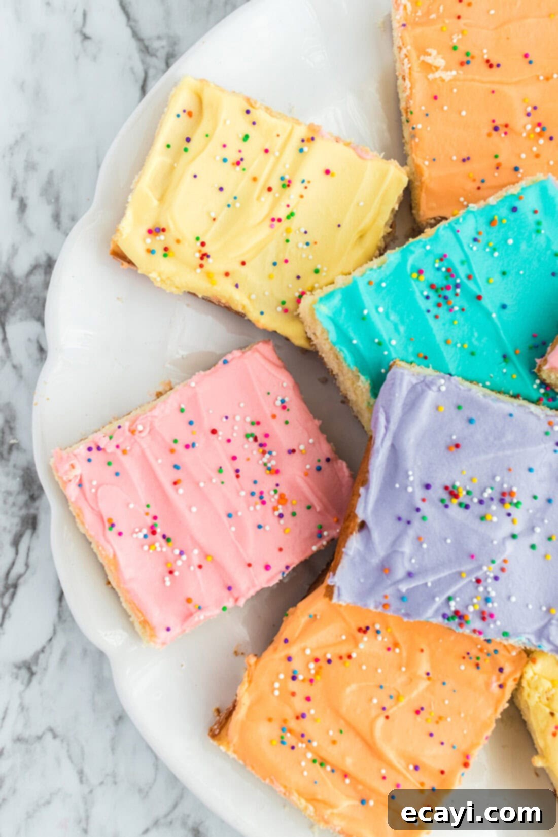 Irresistible Frosted Sugar Cookie Bars 13 Close up photo of half a plate of Frosted Sugar Cookie Bars, highlighting the fluffy frosting and soft cookie base.