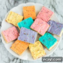 Irresistible Frosted Sugar Cookie Bars 14 Delicious Frosted Sugar Cookie Bars with colorful sprinkles.