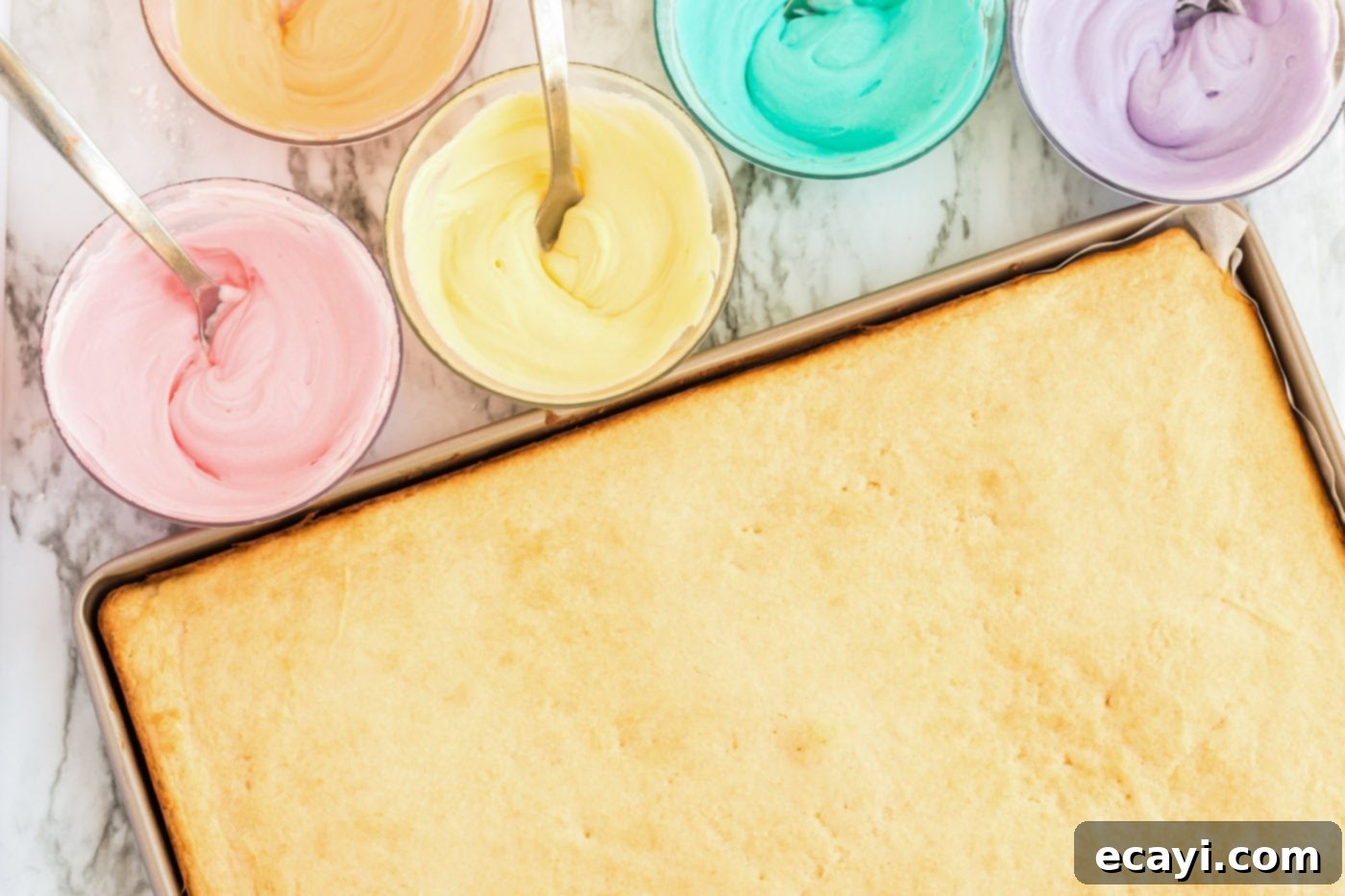 Irresistible Frosted Sugar Cookie Bars 10 A baked pan of sugar cookie bars alongside several small bowls of frosting, each tinted with a different vibrant food coloring.