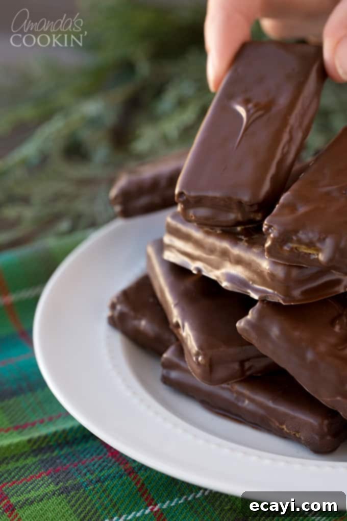 Peanut butter and chocolate lovers and going to go crazy for these super easy to make homemade candy bars. Great for snack or gift giving! #chocolate #candy #desserts #homemade #homemadecandy #candybars #nobake #peanutbutter #valentinesday #peanutbutterdesserts Homemade candy bars dipped in chocolate and arranged neatly on a plate, ready to be served