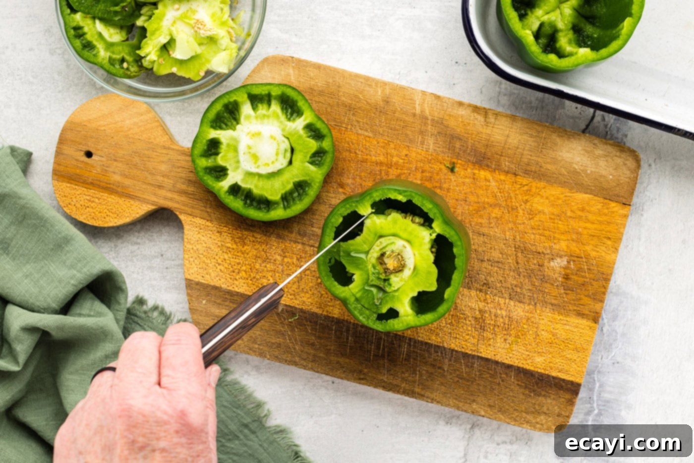 Chili Cornbread Stuffed Peppers 5 A sharp knife carefully removing the white membrane from inside a hollowed-out green bell pepper.