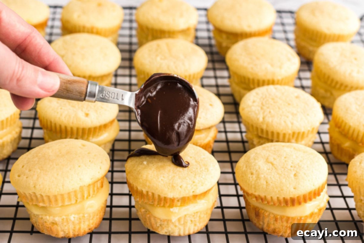 Topping Cupcake with Chocolate Ganache Adding a generous spoonful of chocolate ganache to the top of a filled cupcake