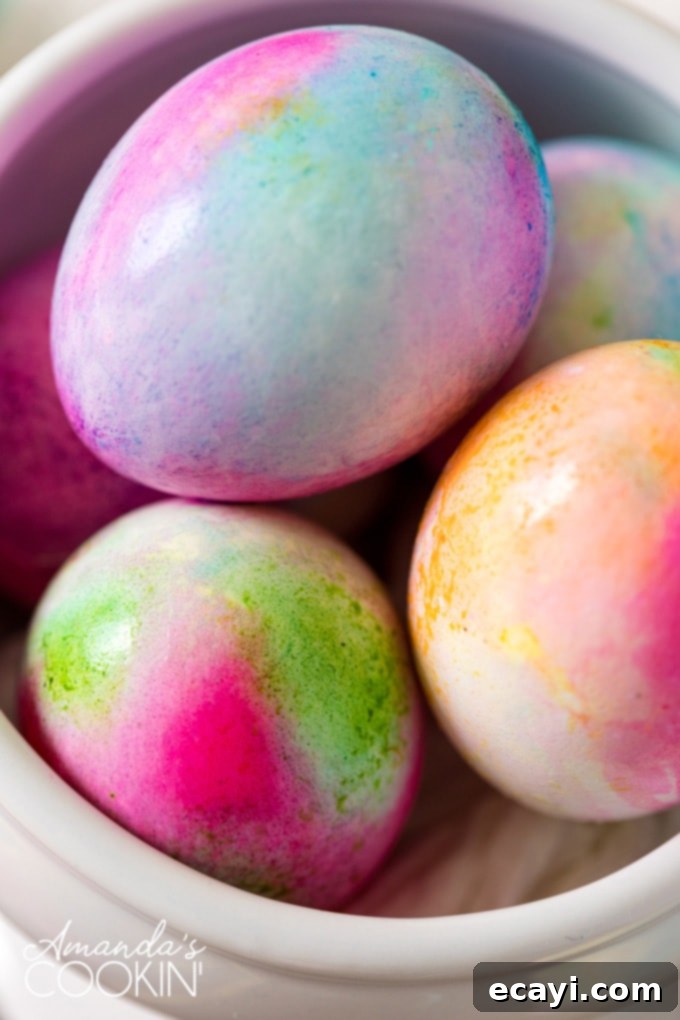 Create stunning and unique tie-dye Easter eggs with these simple methods. Beautifully patterned tie-dye Easter eggs arranged on a platter