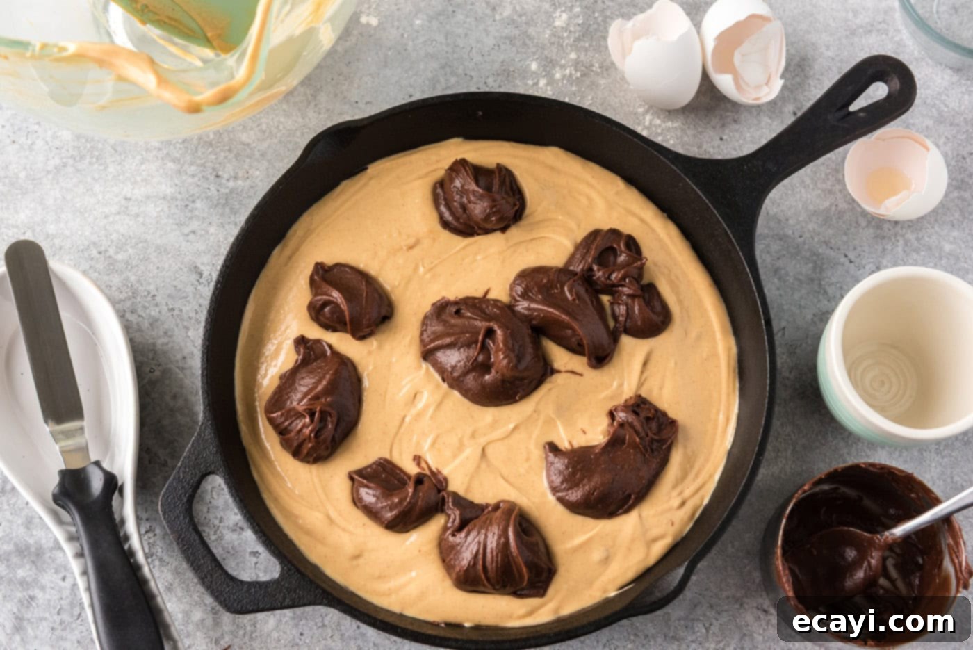 Deep Dish Peanut Butter Brownie 13 dollops of brownie batter on top of peanut butter mixture in a cast iron skillet